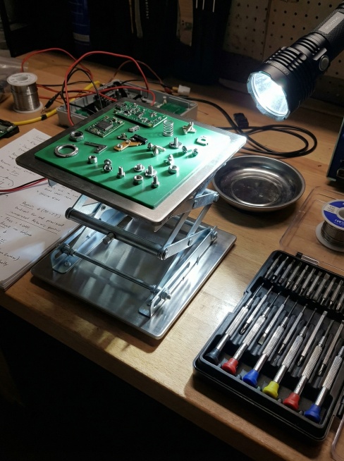 工作台一角，升降台用来放置从电器或家具上拆下的精密零件和螺丝。旁边是螺丝刀套装，强光手电照射，凸显其作为维修项目临时组织平台的作用。 比例3:4预览效果