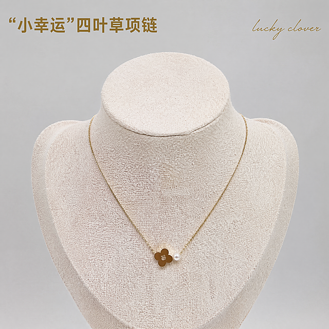 [主图-1] 四叶草珍珠项链颈模佩戴展示首图。[氛围风格] 精致简约高级感，凸显锁骨链轻奢气质。[画质] 商业珠宝摄影质感，光线柔和通透，产品清晰真实，画面干净高级，精修去除原图灰尘和杂乱纹理。[元素] 金色四叶草配珍珠吊坠项链佩戴在浅米色亚麻颈模上，项链整体居中展示，保持产品外观（物理结构、材质质感、颜色）与输入产品图绝对一致，杜绝任何变形和色差，精细化处理。商品主体占比严格控制在70%左右，画面满屏无边框，背景替换为干净浅灰色纯色背景，凸显项链主体。[光影] 柔光箱主光均匀打亮项链金属和珍珠，窄条轮廓光勾勒链条轮廓，金属光泽自然，珍珠通透干净，高光不溢色，暗部有层次。[配色] 主色调浅灰干净背景，搭配项链金色和珍珠白，简约高级。[视角构图] 平视视角，景深适中，项链轮廓完整不裁切。[文字版式] 左上负空间左对齐留安全边距，大字主文案“小幸运”四叶草项链，金色粗体字与背景形成对比，清晰不遮挡产品，右上角加小字号手写英文“lucky clover”装饰。[比例分辨率] 1:1比例，4k分辨率，文字清晰锐利，画面超高清。[负向提示词] 变形，水印，文字错乱，产品图模糊，背景杂乱，廉价塑料感，文字遮挡主体