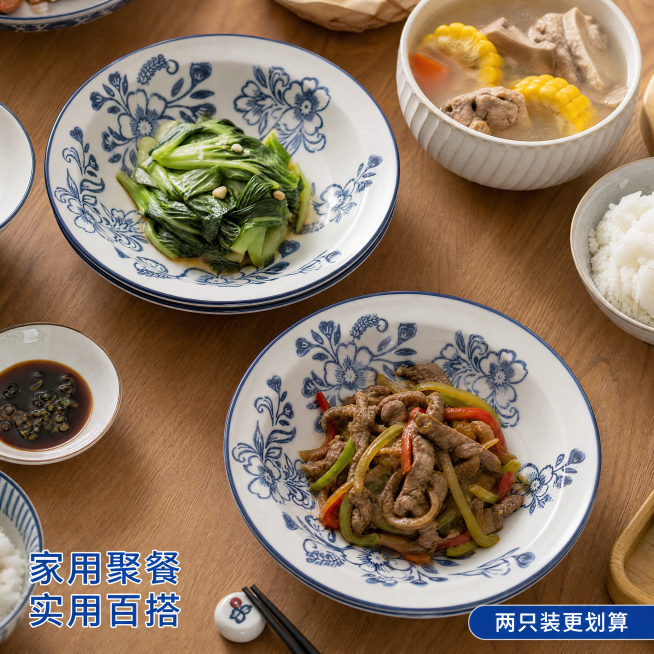 [主图-4] 青花陶瓷盘家庭餐桌使用场景；[氛围风格] 真实生活场景，温馨实用；[画质] 纪实商业摄影，自然通透；[元素] 青花陶瓷盘摆放在家庭餐桌中央，盘中盛放简约家常菜，周围搭配其他餐具，营造真实预览效果