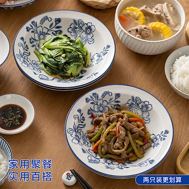 [主图-4] 青花陶瓷盘家庭餐桌使用场景；[氛围风格] 真实生活场景，温馨实用；[画质] 纪实商业摄影，自然通透；[元素] 青花陶瓷盘摆放在家庭餐桌中央，盘中盛放简约家常菜，周围搭配其他餐具，营造真实用餐氛围。陶瓷盘外观颜色图案与原图一致，两只盘同时展示在餐桌上。产品占比约60%，背景为整洁厨房环境，不过分杂乱；[光影] 室内自然光线，温馨柔和，真实生活感；[配色] 木质餐桌暖色调衬托蓝白餐具，自然和谐；[视角构图] 俯视餐桌场景，展示使用状态；[文字版式] 左下角文字写"家用聚餐 实用百搭"，蓝色清晰字体；右下角标注"两只装更划算"；[比例分辨率] 1:1 比例，2048*2048像素，超高清；[负向提示词] 过度修饰，背景杂乱，产品变形，文字遮挡主体