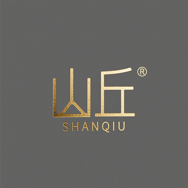Logo设计，民宿logo设计，风格：金属质感+极细线条，字符“山丘”，下面一行小字“SHANQIU”，字体：纤细衬线体，整体呈现优雅轻奢感，适配烫金工艺，纯色背景