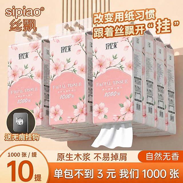 将图中所有悬挂的抽纸外包装图案完全替换为第一张参考图的樱花粉色包装设计：粉色渐变底色、樱花花朵花枝图案、"好忆家"黑色品牌名、粉色盾牌形区域内的"FACIAL TISSUE"白色英文字样和"亲肤挂抽式纸巾"中文字样，包装整体外观、挂孔、侧面信息栏的位置和形态保持不变。保持原图的构图、悬挂方式、光影、背景、所有文字文案和其他元素完全不变，仅替换抽纸外包装的图案。