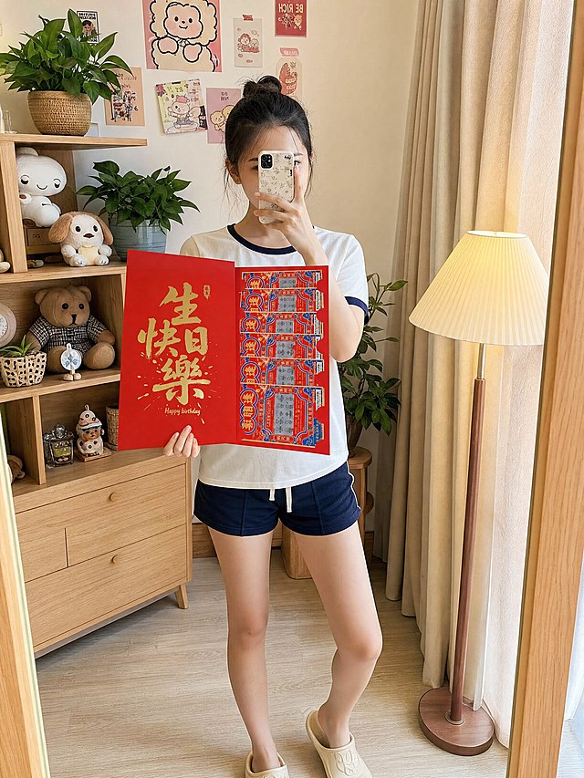 画面中心为女生，以对镜自拍的姿势站在全身镜前：一只手举着手机挡住半张脸，另一只手自然拿着刮刮乐红包，红包实物大小为35*20cm，在图中比例要够大，红包样式、大小、排版、设计、尺寸完全保留，为左右两页并排展开样式，左页是生日快乐，右页是彩票，禁止改动排列形式。背景换成简约原木风置物架，架上摆放绿植盆栽、可爱玩偶与精致小饰品，墙面贴着清新风格的装饰贴纸。右侧是布艺遮光帘，帘旁摆放着落地小台灯，整体光线为明亮的室内自然光，搭配暖黄色的灯光，氛围轻松有生活气息。高清写实手机对镜自拍风格，带有轻微的日常生活感，色彩明亮自然，无过度磨皮和滤镜，保留真实的皮肤纹理、衣物质感与环境细节，画面有轻微的镜面反光效果，整体呈现出真实、自然的随拍质感。