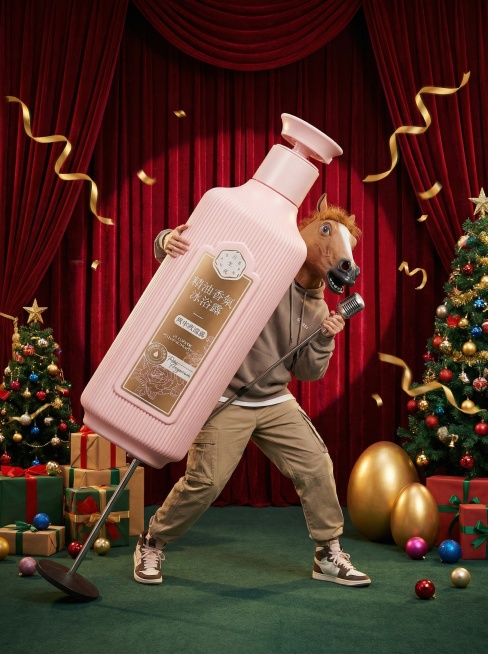 围绕模特构图，带棕色马头面具的模特（时尚年轻的穿搭）手持超级巨大化的产品摆出活泼的姿势握着前面的立麦在一个舞台上，舞台上搭配礼盒、彩球、圣诞树和金蛋，周围飘着金色彩带制造氛围；综艺宣传风格，背后的红幕预览效果