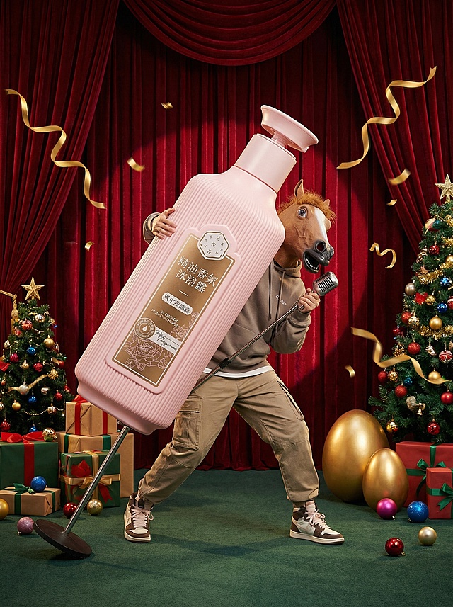 围绕模特构图，带棕色马头面具的模特（时尚年轻的穿搭）手持超级巨大化的产品摆出活泼的姿势握着前面的立麦在一个舞台上，舞台上搭配礼盒、彩球、圣诞树和金蛋，周围飘着金色彩带制造氛围；综艺宣传风格，背后的红幕布+墨绿色地面