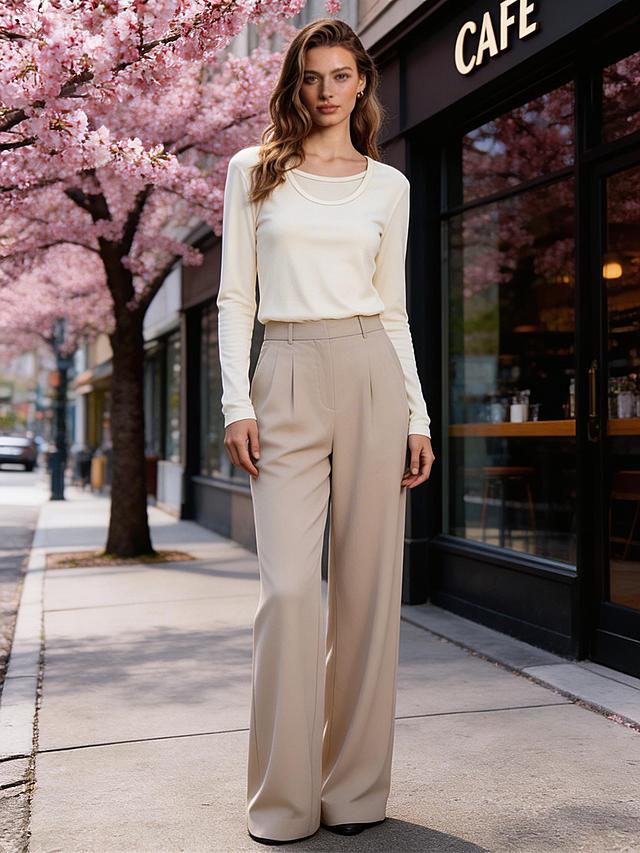 将图2的米白色假两件长袖上衣穿到图1模特身上，还原衣服细节，搭配适合春季的裤子，背景替换为春季街拍实景