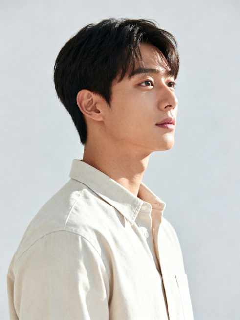 半身男模特，年龄25岁左右，身形挺拔，穿着简约休闲的浅色基础款衬衫，背景为干净的浅灰色纯色背景，光线柔和均匀，面部轮廓清晰，气质阳光自然，画面高清有质感预览效果