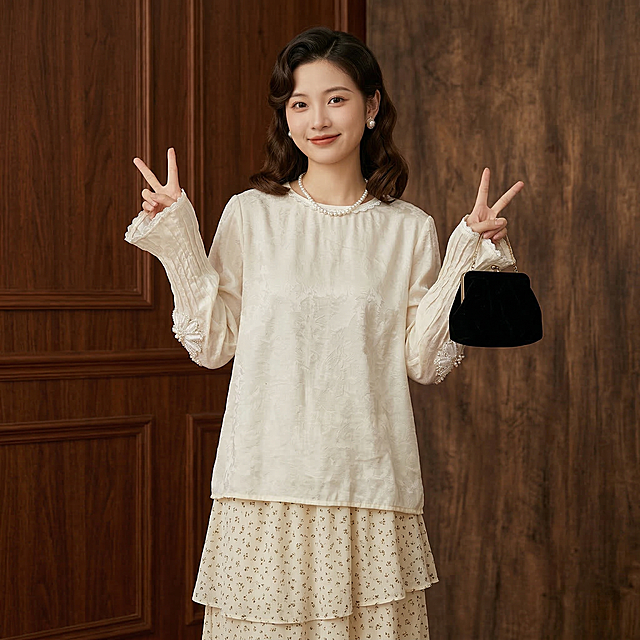 全身照，同一个长相甜美年轻东亚女生，年龄20-25岁，穿着图中米白色提花蕾丝长袖上衣，上衣不塞进下装，叠穿米白色碎花半身裙。留着复古波浪卷，侧分发型，发尾垂在肩前，佩戴珍珠耳饰和珍珠项链，拿着黑色丝绒手拿包，清透自然淡妆，嘴角带着温柔笑意。人物摆拍动作：双手比耶，背景是复古照相馆，暗调灯光搭配木质背景布，充满怀旧感。画面采用自然柔和的日间散射日光，整体暖调通透，没有生硬阴影，色彩温润自然，人物对焦精准，皮肤质感真实细腻，整体画面充满松弛慵懒的春日日常感，生活气息十足