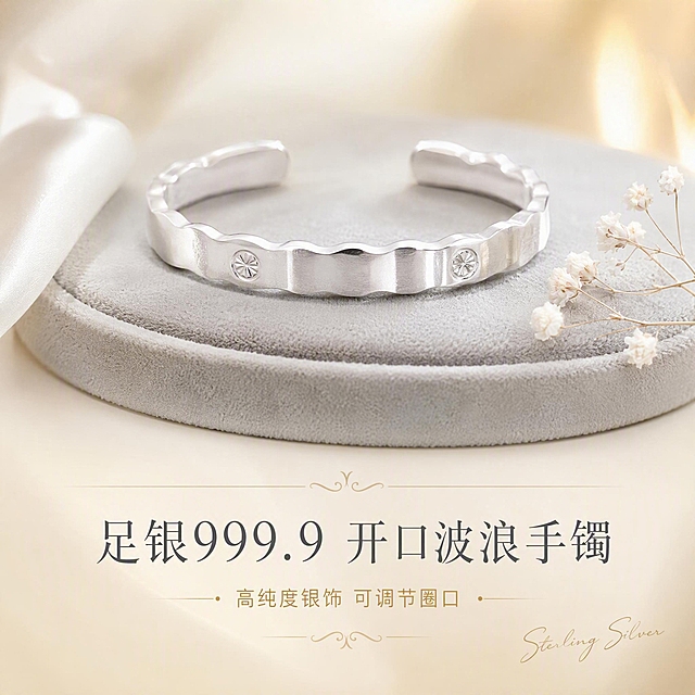 [主图-1] 首图点击率，展示足银999.9开口波浪边手镯的整体高级质感与礼赠氛围。
[统一基调] 精致高级珠宝摄影风格，背景为奶油白渐变搭配浅香槟金柔光晕染，整体色调干净明亮；标题字色为深银灰色，辅助字色为浅金色；字体使用纤细优雅的衬线体，字号层级分明；整体无厚重色块，仅用极细的金色线条做轻装饰。
[画面] 手镯居中偏上放置，主体占比约65%，开口波浪边造型完整展示，镯身的圆形钉砂花纹清晰可见，银质表面光滑亮泽无划痕指纹；手镯放置在浅灰色绒面首饰垫上，旁边点缀一小片白色丝绸和一朵迷你白色满天星干花，营造高级礼赠氛围；画面下方留出负空间放置文字。
[光影质感] 商业珠宝摄影柔光箱打光，主光从左上45度打下，银镯表面形成柔和的条状高光，边缘有窄条轮廓光勾勒金属质感，底部有自然的浅灰色接触阴影，整体通透干净，银质呈现冷白亮泽不发灰。
[配色] 背景奶油白+浅香槟金渐变，银镯本体亮银色，文字深银灰+浅金色点缀，整体低饱和高级感。
[文字版式] 画面底部居中放置主标题「足银999.9 开口波浪手镯」，字体纤细优雅；主标题下方放一行更小的辅助文案「高纯度银饰 可调节圈口」；右下角加一行极小的手写体英文装饰「Sterling Silver」；所有文字不遮挡产品主体。
[输出要求] 1:1正方形比例，2K高清，产品清晰锐利，文字清晰可读；负向：变形、错字、模糊、杂乱背景、水印、平台Logo、划痕、指纹、廉价塑料感、粗黑描边字。