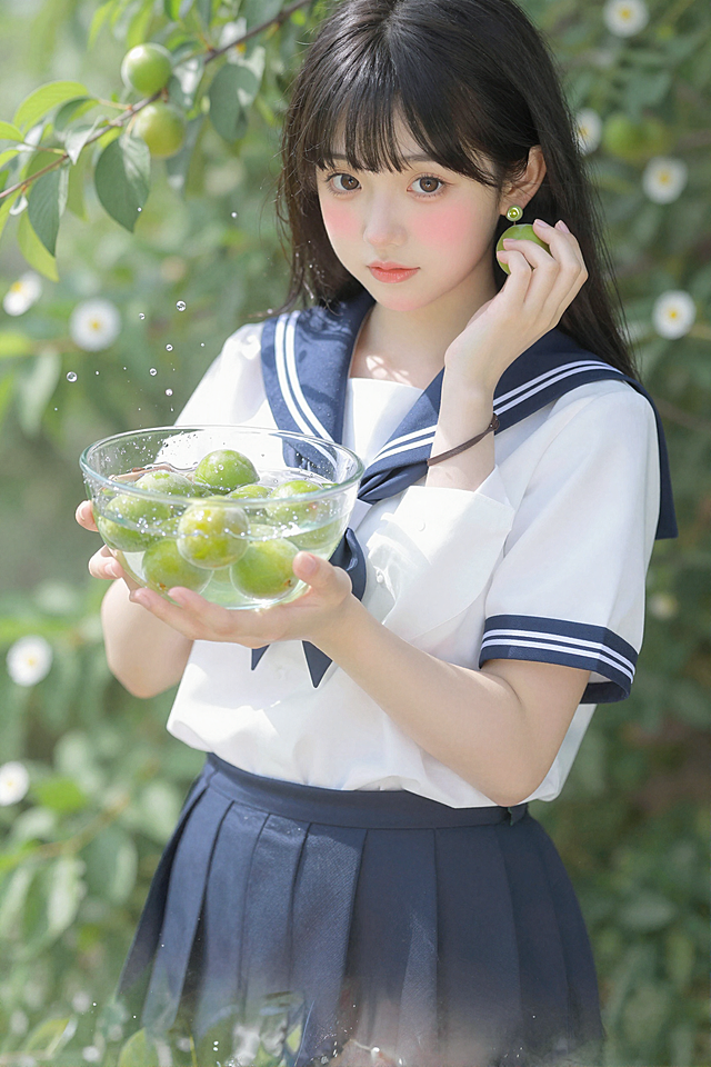 超写实日系插画，清新治愈系夏日青梅少女风景：主体为一位身着白蓝相间水手服的黑发少女，齐刘海微卷，眉眼温柔，脸颊泛着淡粉红晕，眼神清澈明亮。她一手托着盛满清水与青李的透明玻璃碗，水珠飞溅，另一手轻触碗外的青李，耳饰与周围枝叶上的青李呼应，细节通透灵动。背景是繁茂的翠绿枝叶与白色小雏菊，阳光透过叶片洒下斑驳光影，气泡与水珠悬浮空中，光线明亮柔和，氛围清新治愈，充满夏日的清冽生机。整体以白、绿、蓝为主色调，融合日系动漫质感与自然治愈风格，细节极致饱满，8K超高清。