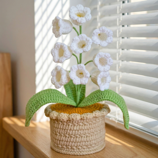 将白色钩织铃兰盆栽产品放置在卧室的浅色窗台上，背景是白色百叶窗，自然日光，清新温馨氛围，产品保持原样不变，最终图片尺寸为1200x1200预览效果