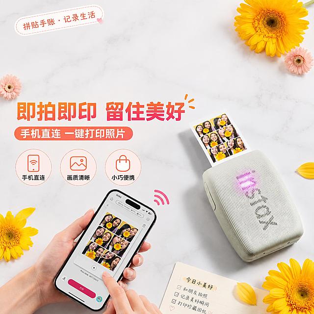 移除画面上方的五张打印照片（相纸），保留打印机出片口正在输出的那一张照片。其余元素保持不变：主标题"即拍即印 留住美好"、副标题"手机直连 一键打印照片"、三个卖点图标标签"手机直连""画质清晰""小巧便携"、左上角"拼贴手账·记录生活"标签、手持手机、打印机产品本体、黄色非洲菊花朵装饰、大理石桌面背景、右下角便签纸全部保留。画面整体风格、色调、构图和产品外观与原图保持一致，移除五张相纸后上方区域自然过渡，背景干净协调。