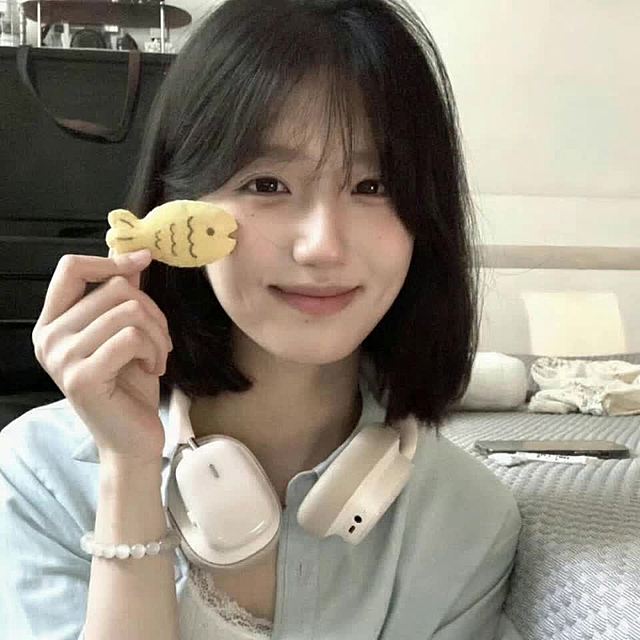 少女手持鱼形饼干，笑容温暖治愈