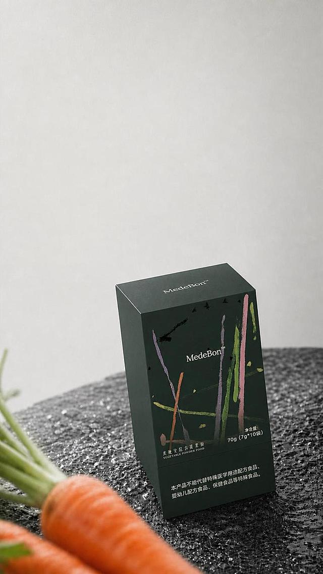 调整画面中的MedeBon蔬菜粉包装盒，使其与场景更协调：1. 调整包装盒的光影与明暗，让受光面泛起环境冷灰色调，暗部与边缘映射台面深灰色光晕，与场景光源完全统一；2. 微调包装盒透视角度与倾斜度，与台面透视更贴合，底部与台面接触更自然；3. 增强包装盒底部的投影与环境反光，使其更真实地落于深色纹理台面上；4. 保留包装盒上所有文字、图案、颜色与结构不变，整体画面风格、构图、胡萝卜前景与背景均保持不变。