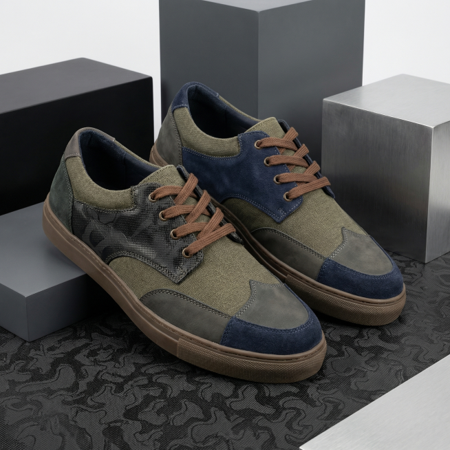 生成一双男士帆布鞋，鞋子整体是拼色设计，搭配不同材质。其中某一处使用图片提供的黑色皮革，带有黑色皮革纹路，颜色符合男士沉稳风格。鞋子放置在黑色皮革材质上方，背景是简洁的电商几何场景，整体风格商业产品图预览效果