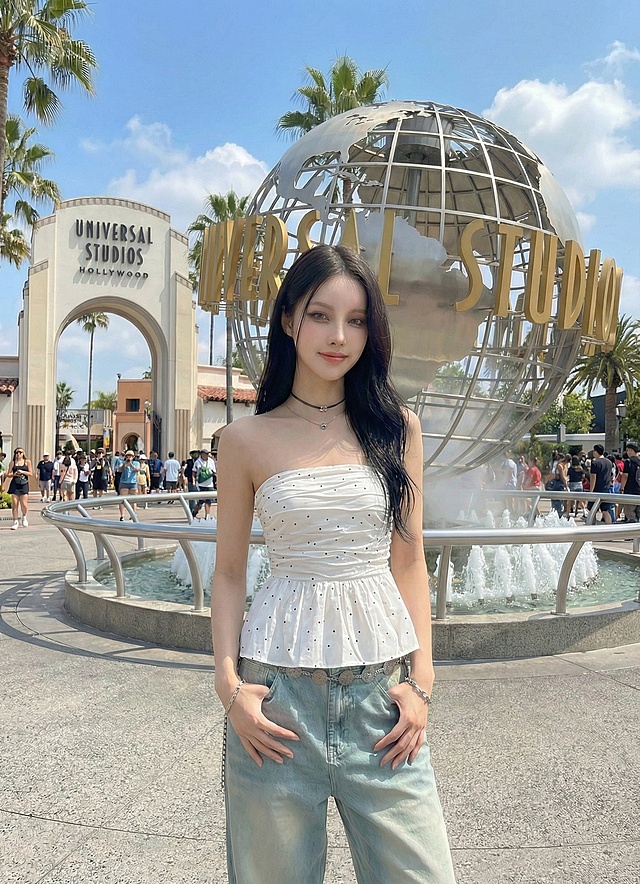 把图2上衣换到图1模特身上，保持模特1并保留图1背景和姿势精准替换上衣，保持原风格，确保色彩光影自然融合