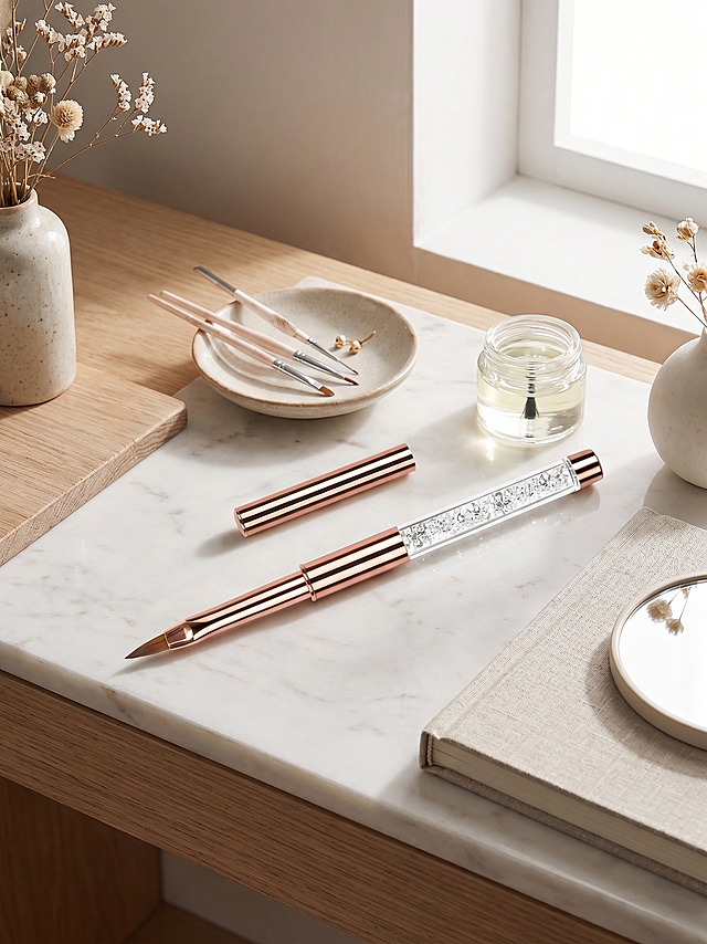 保持这支玫瑰金镶钻美甲笔的产品细节不变，将纯白色背景替换为高级简约的美妆工作室桌面场景，柔和自然光线，突出产品质感