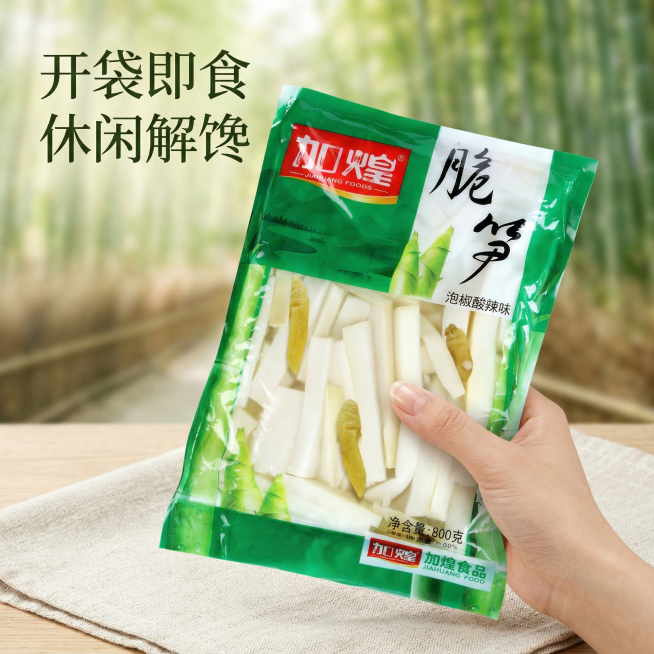 垫图为用户提供的加煌脆笋泡椒酸辣味商品图，生成第四张泡椒脆笋电商主图，模拟手持包装袋展示的生活场景，一只手自然拿着大袋泡椒笋，背景是干净的野餐布，搭配浅景深的竹林背景，营造休闲野餐的食用场景，代入感强预览效果
