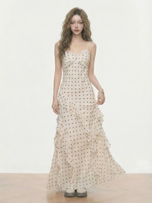 模特穿着同款米白色波点吊带连衣裙，做出抬手轻拂裙摆的姿势，展示连衣裙的垂坠感和灵动的荷叶边，背景保持简洁纯色预览效果