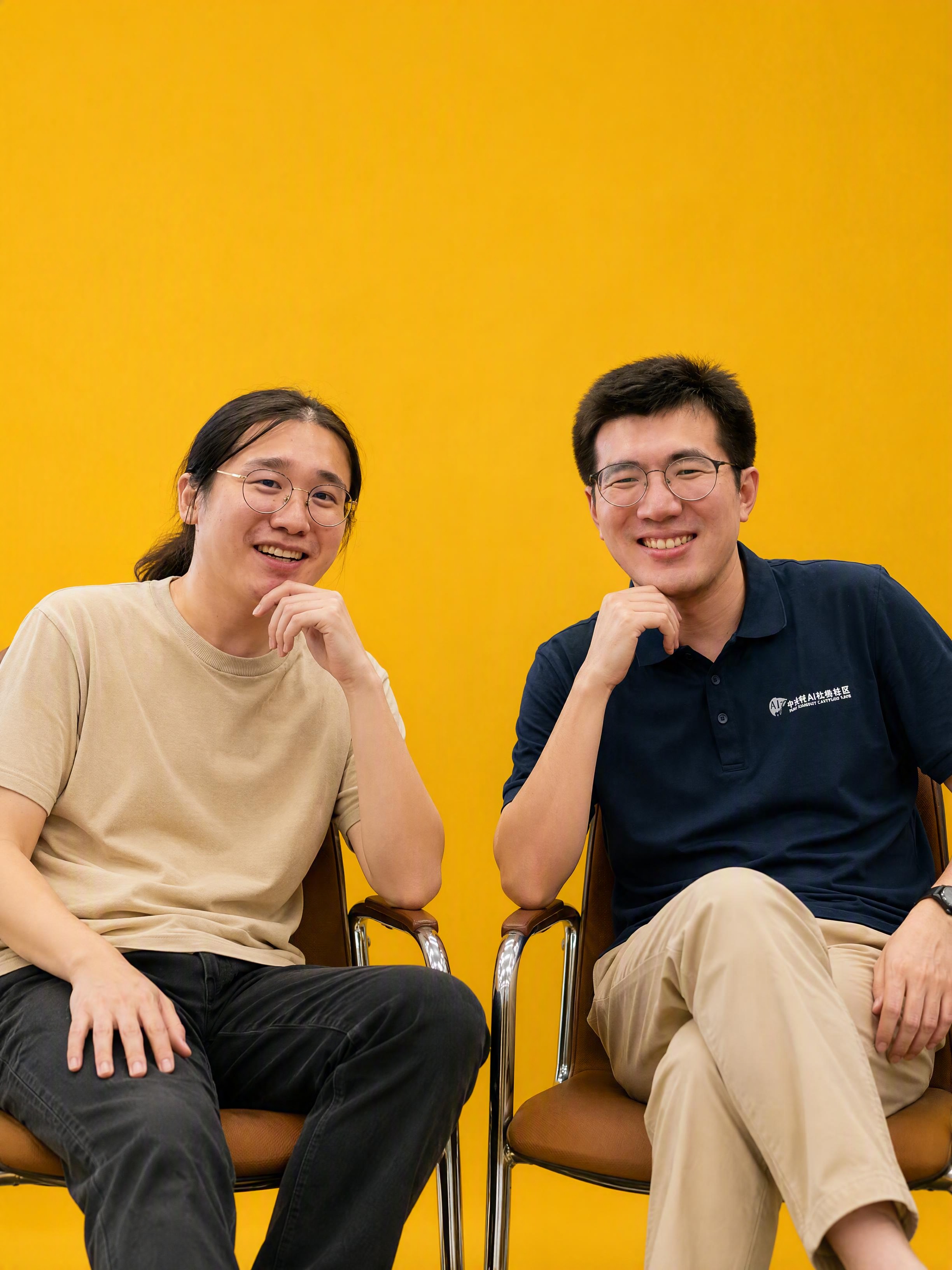 参考图2的构图和坐姿，将图1中两位男士改为坐在椅子上的访谈坐姿… - 图片创意预览