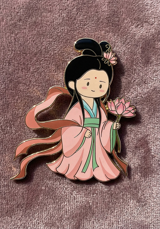 将图中Q版古风持莲女子形象转换为第二张图的金属徽章质感，保留原形象所有细节不变