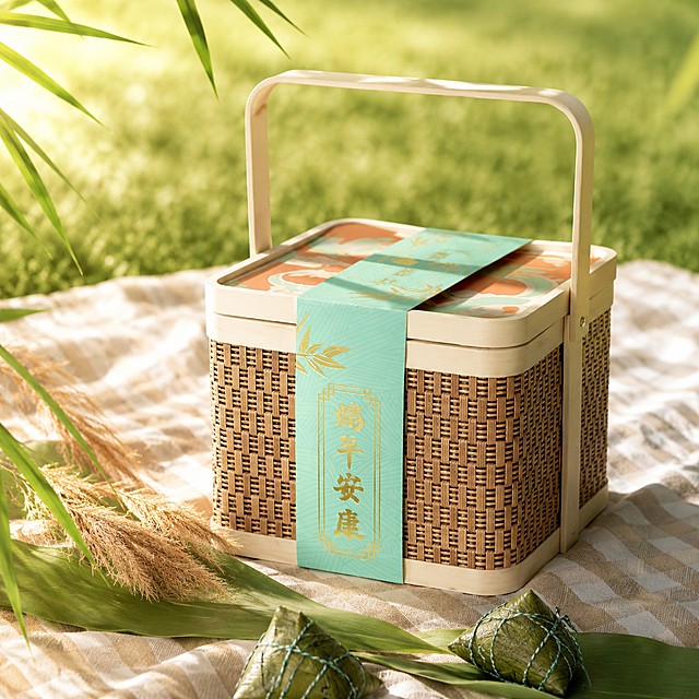 [场景图2]浐灞喜来登「竹影呈祥」端午粽子礼盒，户外草坪野餐场景背景
[氛围风格]清新自然端午户外野餐氛围，轻松愉悦
[画质]商业自然光摄影，清晰通透，充满生机
[元素]礼盒放置在米白格子野餐布上，周围点缀新鲜粽叶和几支芦苇，自然阳光洒下，礼盒保持原图外观材质颜色完全一致，不变形色差，自然融入户外野餐场景
[光影]正午自然暖阳逆光，透过粽叶产生自然丁达尔效果，粽叶轮廓透亮，礼盒表面光影斑驳，富有自然生机
[配色]绿色草坪搭配浅蓝天空，格子野餐布米白底色，整体清新自然浅色调，突出礼盒主体
[视角构图]俯拍，礼盒位于画面视觉中心，占比约70%，背景虚化草坪和天空，突出主体
[比例分辨率]1:1比例，4K分辨率
[负向提示词]变形，水印，产品模糊，背景杂乱，比例失调，色差