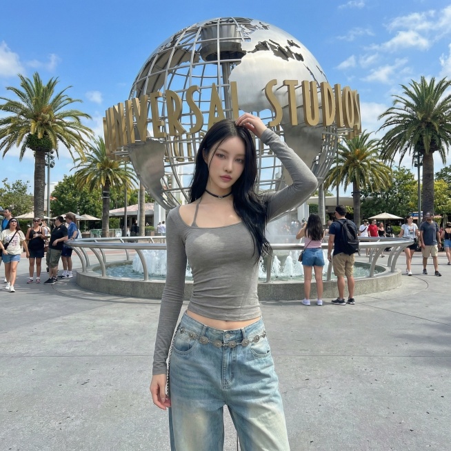 将背景替换为环球影城标志性大球场景，保持模特和服饰不变，更换为抬手整理头发的姿势预览效果