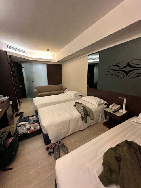 消除这张酒店房间图里床上的黑色背包、黑色小包等所有黑色物品，保留其他物品和场景原貌，修复后的区域和周围自然融合预览效果