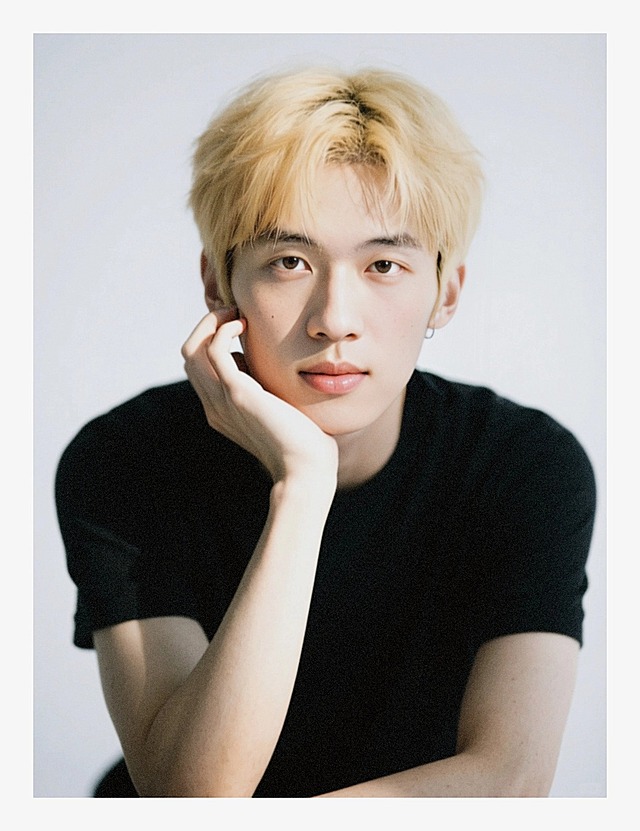 一个男生，金色头发，黑色短袖，单手托腮，脸部强曝光光线，正脸特写，低饱和度，加强阴影，白色背景。