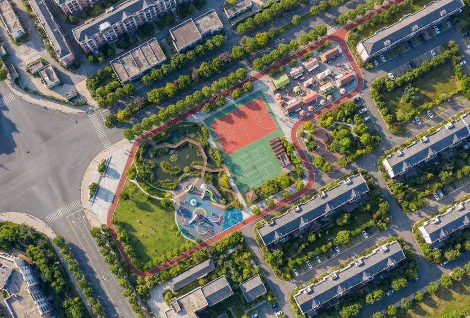 根据这张公园平面图生成写实风格的鸟瞰效果图，保留所有规划功能区域：生态湿地、篮球场羽毛球场、商业小吃街、儿童游乐区、开阔草坪、健身步道，整体为城市社区公园，写实鸟瞰视角，自然绿植覆盖，光影真实预览效果