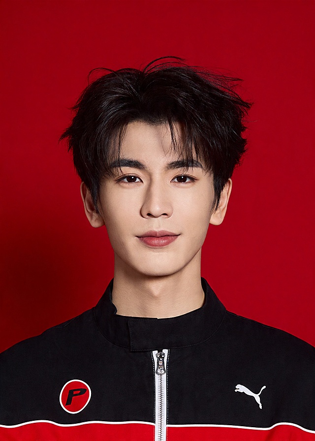 保留第一张图中人物发型､脸型､年龄特征生成标准样式纯正面证件照;人物主体严格居中,头部大小与位置严格对齐第二张图,双肩水平平衡,面部中轴线对齐画面中心,正视前方;标准证件照构图,人物绝对居中;头顶上方距离上边缘高度10%,下巴距离画面下边缘高度30%,人物主体占比约68%;肩部平展与画面水平轴平行;头部占比严格对齐第二张图;标准焦段50mm,纯正面,入境范围头部至胸部以上区域,F/4光圈(兼容F/2.8-F/4区间),平视视角(镜头与人物视线完全齐平),正视视图;人物绝对居中(居中构图),位于画面中心;严格限定标准证件照规格;视线水平(瞳孔连线与画面水平线平行);提亮肤色,消除暗沉,清透裸妆,隐形毛孔,均匀肤色,唇色自然提亮;肤色白皙细腻,肤质呈现匀净哑光质感(自然白皙);轻透裸妆+重点提亮;唇色润泽(半哑光质地);眼神澄澈,看向镜头,气质自信,嘴角微微上扬表情自然;耳廓可见度一致;肩部平展,肩线与画面水平轴平行;头肩比例协调呈现;免冠,不戴帽子,无头饰,无发带,不戴眼镜,无胡子,面部无痣,消除面部瑕疵,双耳对称露出,双肩水平且平衡,头部占比严格对齐垫图,禁止大头照(画面铺满画布,无边框留白);身着黑红拼色运动立领外套，带品牌装饰图案，不戴帽子，无头饰;柔和正面顺光均匀柔光,面部明亮无硬影,背景均匀提亮,画质清晰,零噪点降噪;面部清晰;均匀柔和布光,无明显阴影,面部光影干净,柔光正面打光,自然光影过渡,皮肤质感细腻,哑光质感;极简纯色红色背景，背景亮度均匀统一(哑光质感);高清锐利画质,细节清晰可见;零噪点处理;色彩还原自然,专业证件照质感,高清人像质感,细腻皮肤纹理,严格按照第一张图内容生成,分辨率4K;禁止裁切头顶, 禁止额头被截, 禁止超大头, 禁止主体溢出画面, 禁止偏头/倾斜;头顶上边距8-10%, 头部高度60-68%, 双眼高度56-58%, 严格对齐第二张垫图;画面比例5:7