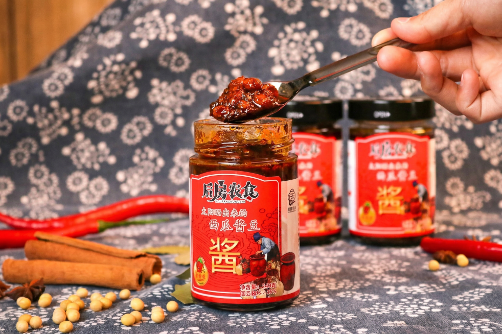 精修这张美食照片，处理成专业商业摄影风格：重点增强酱料表面的油润光泽感，使其晶莹剔透；提高色彩饱和度和对比度，让酱色更加浓郁诱人；强化微距下的纹理细节，突出酱料的浓稠度和颗粒感；添加一层柔和的暖色调美预览效果