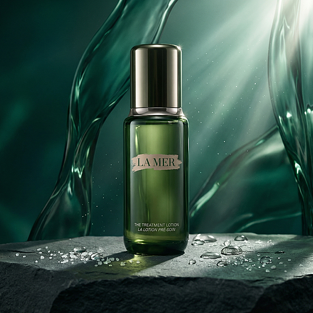 严格还原参考产品图，海蓝之谜焕肤水保留标志性的墨绿色瓶身、金属瓶盖、简洁的方形轮廓，瓶身保留品牌LOGO和英文名称“THE TREATMENT LOTION”，产品外观必须与参考图完全一致，不得改变包装设计、配色方案或品牌元素，保持产品玻璃瓶身的高光质感与金属瓶盖的光泽感。极致高清的商业摄影风格，模拟深海光影。主产品置于画面中央偏下的黄金分割点，背景为流动的墨绿色液体抽象雕塑，与海蓝之谜的品牌色调完美融合。一束柔和的侧逆光从右上方照射，穿过背景的液体，形成细腻的光斑和丁达尔效应，投射在哑光质地的深灰色礁石台面上。台面边缘散落着几颗晶莹剔透的水珠和极小的海盐结晶，折射出微光。整个画面色调深沉、神秘、纯净，传达出一种奢华、治愈、源自深海的强大生命力量。视觉焦点集中于瓶身，高光处锐利，暗部细节丰富。避免出现：塑料质感，廉价反光，杂乱背景，鲜艳色彩，暖色调，阳光直射，干燥环境，灰尘，划痕，指纹，模糊，过曝，阴影过重，构图拥挤，现代家居，电子产品，鲜花，绿植，黑色背景，纯色背景，卡通元素，字体错误，LOGO缺失，颜色偏差，瓶身变形，瓶盖歪斜，标签起泡