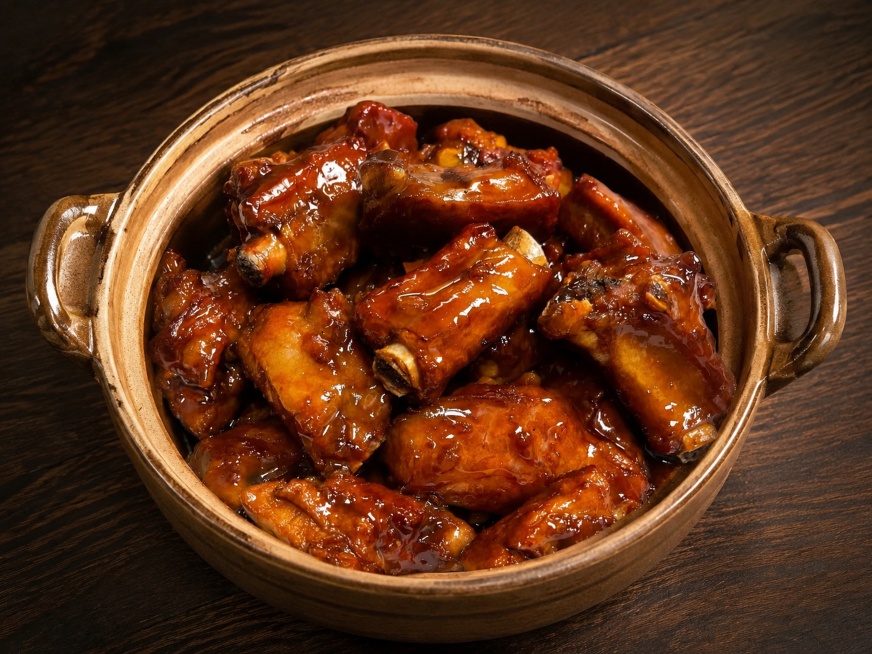 超写实美食摄影，将原图中的糖醋排骨完整转移到砂锅中盛装
主体：糖醋排骨严格参照上传产品图，完整保留所有排骨的大小、数量、形状、颜色和红亮酱汁，将排骨完整装入陶土砂锅内，砂锅为陶土褐色，保留排骨完整不裁预览效果
