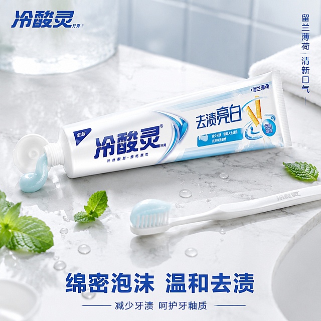 [主图-3] 冷酸灵去渍亮白牙膏质地与使用场景展示
[氛围风格] 清新浴室场景，真实使用感，洁净清爽
[画质] 商业摄影质感、光线柔和通透、产品清晰真实、画面干净高级
[元素] 画面中央冷酸灵去渍亮白牙膏斜放在白色大理石台面上，牙膏盖打开，管口挤出一小段淡蓝色膏体，膏体有细腻光泽；旁边放着一支白色牙刷，刷毛上沾有少量牙膏泡沫；背景是模糊的浴室瓷砖墙，带有淡淡的水雾效果，营造刚刷完牙的清新感；台面上散落几片新鲜薄荷叶和几滴晶莹水珠；左上角冷酸灵品牌Logo。保持冷酸灵去渍亮白牙膏产品外观与输入产品图绝对一致，杜绝任何变形和色差，精细化处理。商品主体占比约60%，画面满屏无边框。
[光影] 侧上方自然光，柔和漫射，牙膏管身有自然高光，膏体有通透质感，水珠有明亮反光，整体清新自然
[配色] 主色调白蓝，薄荷绿点缀，大理石灰白纹理，整体洁净清爽
[视角构图] 45度俯视角度，产品斜放构图自然，前景膏体和牙刷引导视线，背景虚化
[文字版式] 左上角品牌Logo；右上角竖排小字"留兰薄荷 清新口气"；底部中央大字"绵密泡沫 温和去渍"，蓝色粗体；下方小字"减少牙渍 呵护牙釉质"。文字放在画面上下负空间，不遮挡产品主体
[输出要求] 1:1比例，文字清晰可辨，超高清商业摄影质感
[负向提示词] 变形，文字错乱，产品图模糊，背景杂乱，水印，电商平台Logo