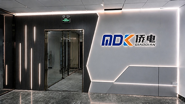 在原始门洞结构不变的基础上，重新设计一种不同风格的公司背景墙，保留LOGO文字"MDK侨电 QIAODIAN"背光字设计，调整格栅和铝塑板的搭配造型，更换不同的线条灯光布局，打造另一种科技感风格
