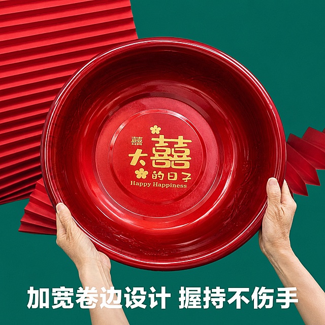[主图-7] 真人双手端盆实景，展示尺寸体感。保持原双手托举喜盆构图，保留"大喜的日子"印花和盆体细节，红色折景绿色背景不变，添加配图标语制作电商主图。保持产品大小、颜色、材质与原图一致，让买家直观感知尺寸。底部添加标语："加宽卷边设计 握持不伤手"，白色粗体大字放置底部，不遮挡盆体，文字清晰。1:1正方形比例，超高清商业摄影质感。负向提示词：变形，文字错乱，产品图模糊，背景杂乱，水印，电商平台Logo