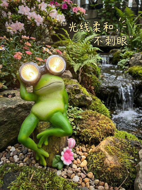 活泼风格，室外假山旁场景，青蛙太阳能灯摆件，突出“光线柔和，不刺眼”卖点，搭配简洁文字说明预览效果