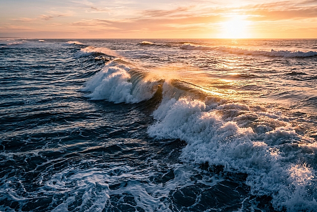 阳光下的海浪，涌动的海面，深蓝色的海水翻涌着白色泡沫，夕阳照在海浪上，碎金铺满浪尖，主色调是深邃的冷蓝色，搭配暖金色的高光