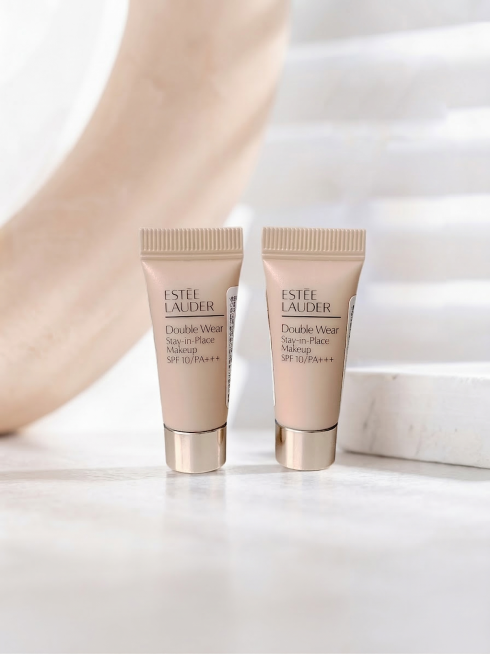 将抠好的雅诗兰黛粉底液小样产品放到这张场景图的白色桌面上，两个粉底液小样自然摆放，光影和场景保持一致，整体自然融合，保留原场景的干净浅色调风格预览效果