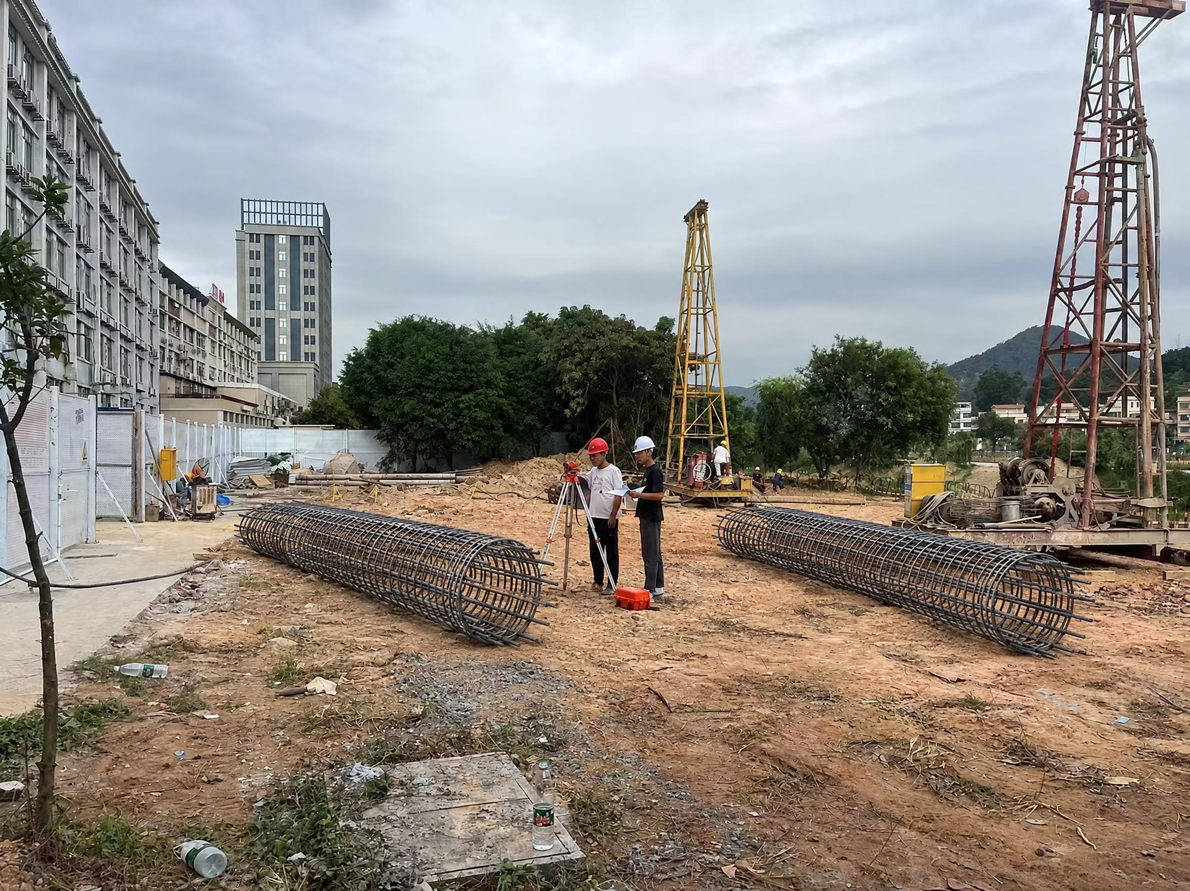 在这张建筑工地照片中，合理添加两个约5米长的圆柱形钢筋笼，参考… - 图片创意预览