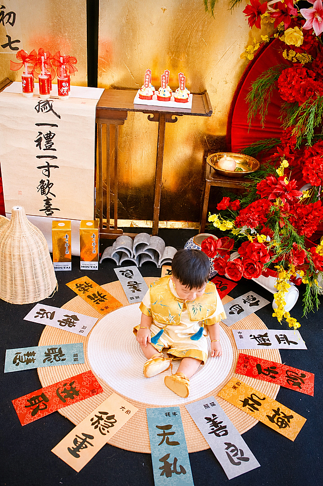 统一调色为小红书风格，画面整体明亮通透，提高亮度和对比度，红色更加鲜艳饱和，金色更加温暖有质感，宝宝肤色自然白皙粉嫩，整体色调偏暖，营造温馨喜庆的氛围，保留原图所有内容和构图不变