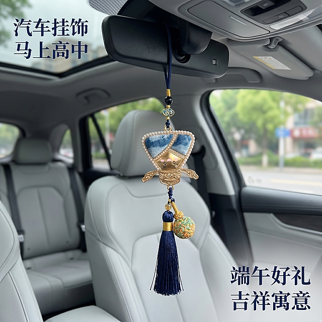 [主图 5] 汽车内后视镜悬挂展示；
[氛围风格] 真实车用场景，端午吉祥；
[画质] 商业摄影质感、光线柔和通透、产品清晰真实、画面干净高级。
[元素] 长款扎染粽子挂饰悬挂在汽车内后视镜上，展示车挂使用效果，保持原产品长款挂饰造型、扎染纹理、金属珍珠流苏细节绝对一致，杜绝任何变形和色差，精细化处理。背景是汽车前挡风玻璃外模糊街景，突出挂饰主体。商品主体占比60%左右。
[光影] 车内自然光，柔和不刺眼，突出挂饰立体感。
[配色] 蓝白挂饰搭配车内浅灰内饰，自然和谐契合端午氛围。
[视角构图] 平视拍摄，完整展示悬挂效果。
[文字版式] 左上主标题 "汽车挂饰 马上高中"，右下轻标签 "端午好礼 吉祥寓意"，文字简洁不遮挡主体。
[比例分辨率] 1:1比例，2k分辨率，文字清晰锐利，画面超高清。
[负向提示词] 变形，水印，文字错乱，产品图模糊，背景杂乱，牛皮癣，配色刺眼，遮挡主体