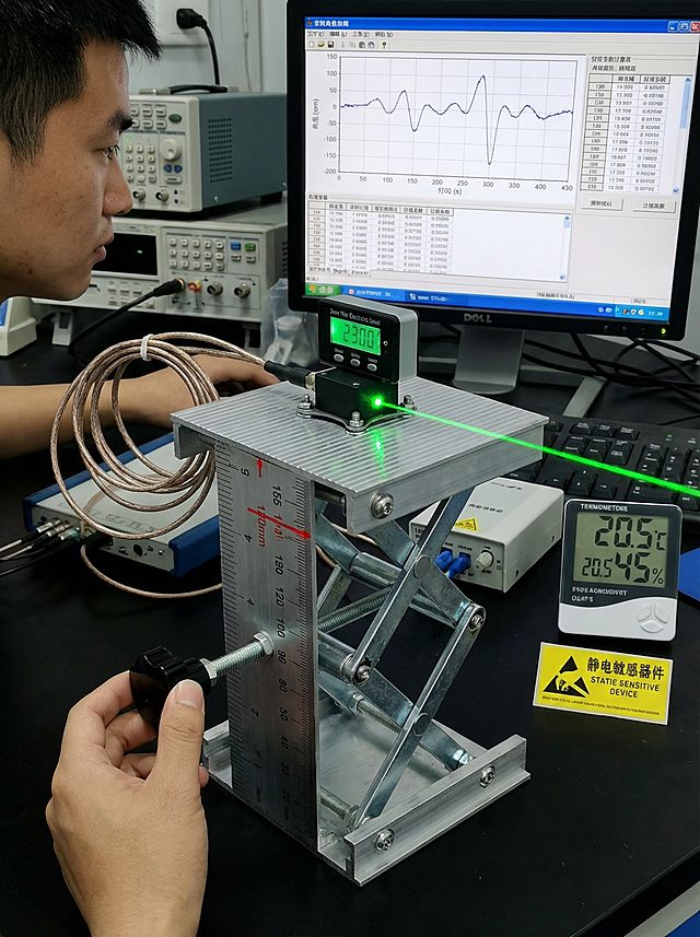 **主提示词**：实验室环境，升降台升至120mm高度（在刻度尺155mm处有红色标记）。台面上安装着MEMS加速度传感器（黑色方形，25×25×10mm），传感器表面吸附着超薄电子水平仪（厚度仅3mm），屏幕显示“Pitch: +0.15°，Roll: -0.03°”。传感器通过柔性线缆连接到数据采集设备。工程师左手微调升降台侧方调平螺丝，眼睛注视着电脑屏幕上实时波形。一道绿色激光从侧面照射，在传感器表面形成光斑用于对准。**关键细节**：- 传感器安装：使用M3不锈钢螺丝，带防松垫圈- 线缆管理：螺旋缠绕线，避免影响测量- 数据显示：电脑屏幕三部分：  左：角度实时曲线（采样率100Hz）  中：传感器原始电压值  右：校准系数计算表格- 环境控制：桌面温湿度计显示“20.5°C，45%RH”- 安全标识：旁边贴有“静电敏感器件”警示标签**动态元素**：- 水平仪数值正在缓慢变化：从+0.15°→+0.08°→+0.02°- 工程师手指正在做毫米级的微调动作- 数据曲线同步滚动更新   比例3:4 不要有文字 人物为中国人「图片1」