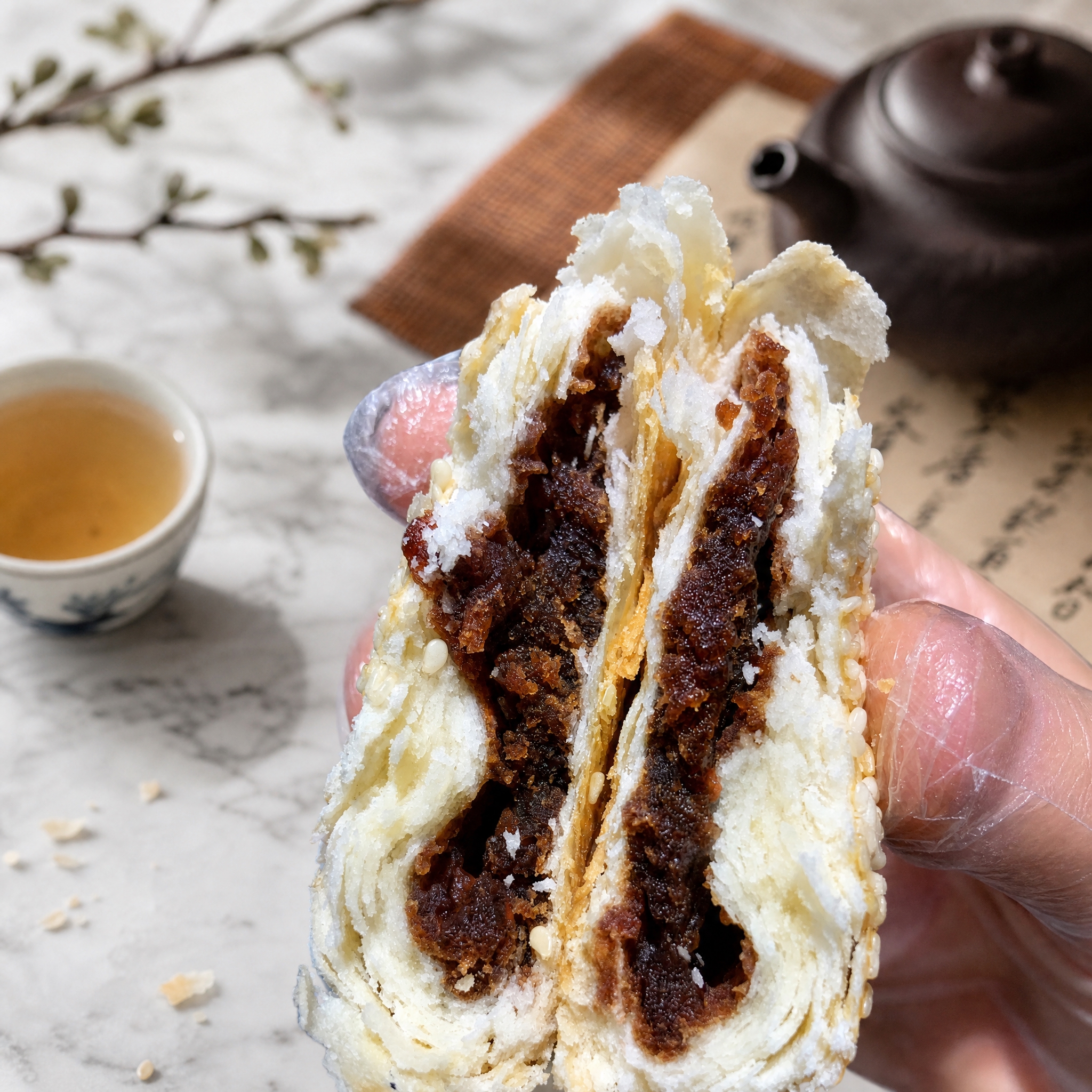 将这张豆沙酥饼的背景替换为简约大理石台面搭配中式茶席场景，保留… - 图片创意预览