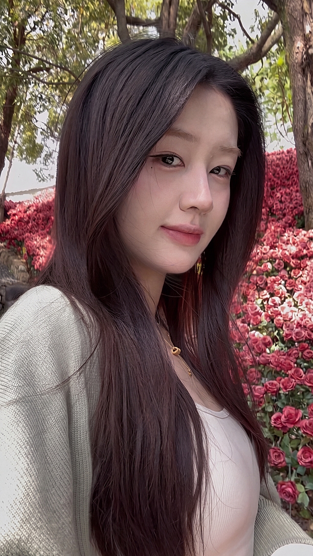 去除图中人物身后右侧出镜的路人，用周围的红玫瑰鲜花背景自然填补，保证过渡自然无违和感，不改变主人物的任何细节，保持画面整体风格一致，最终生成的图片画质清晰清楚