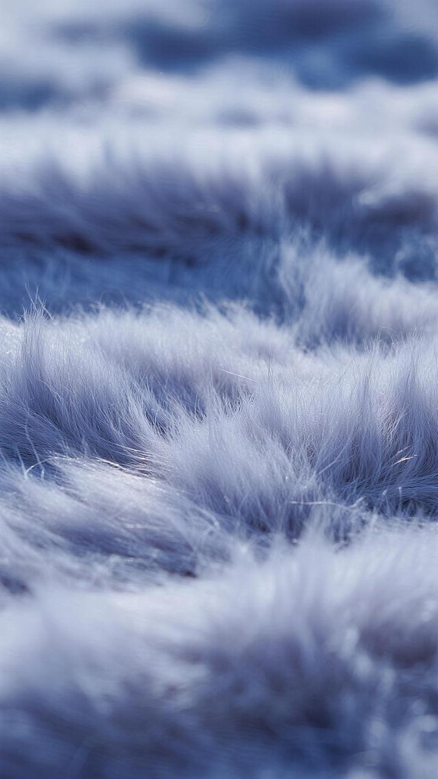 一张毛绒材质的特写图片，保持原有的细腻柔软质感，绒毛根根分明且带有自然的蓬松卷曲，整体呈现出柔和的蓝紫色调，光线从斜上方照射，使得绒毛表面有明亮的高光和深邃的阴影，形成丰富的层次感，色调均匀且过渡自然，营造出温暖舒适的氛围。