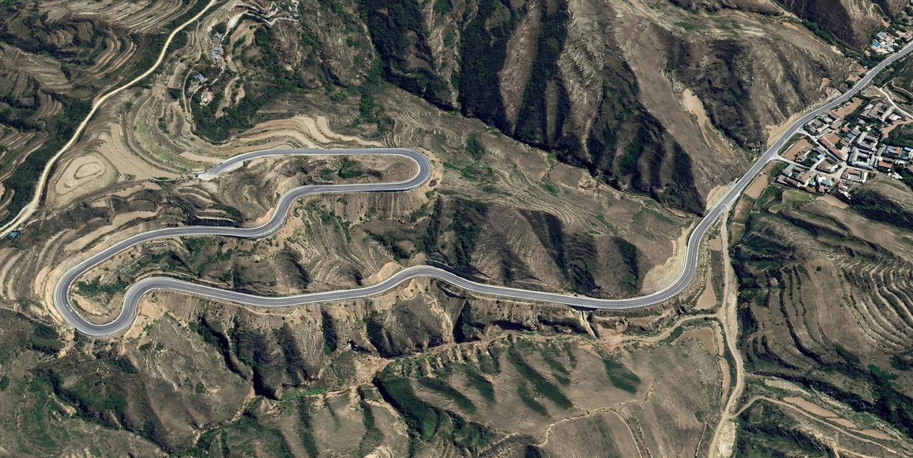 基于该卫星地图的地形高程，沿着图中红色标注的线路，重新设计修建符合三级公路标准的盘山公路，公路路面平整，有清晰的车道标线，沿山势合理蜿蜒排布，适配山地地形，还原山地自然地貌，布线更符合三级公路的设计规预览效果