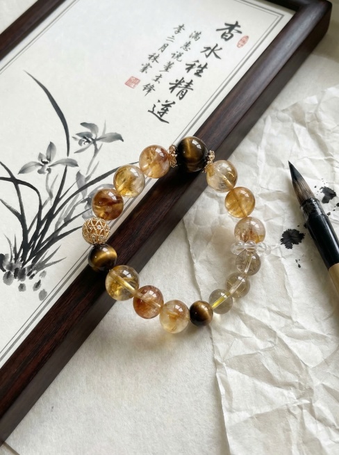 3:4比例，有黄胶花、水晶虎眼石、发晶、白水晶、金属配件材质的圆珠多宝水晶手串放置在书画画板旁，搭配宣纸和毛笔，文雅书卷气氛围，水墨兰草、书法文字元素，凸显中式文化底蕴，真实质感，商业摄影，8K清晰，预览效果