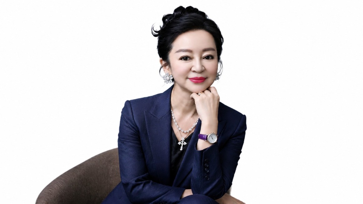 保持人物姿态、发型、妆容和项链手表不变，将背景更换为纯白色，把绿色花朵耳环换成白金色款式，更换西装为更合身合适的款式和颜色预览效果